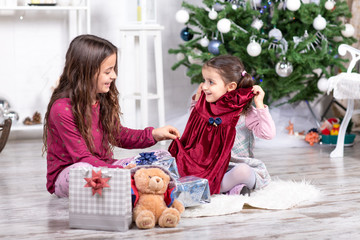 Due sorelline che aprono i regali di Natale