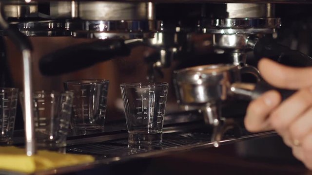 Two cups of espresso being poured from a professional espresso machine