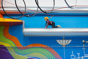 kid climbing on a tube with safety harness