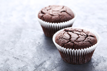 Chocolate muffins on a grey wooden table