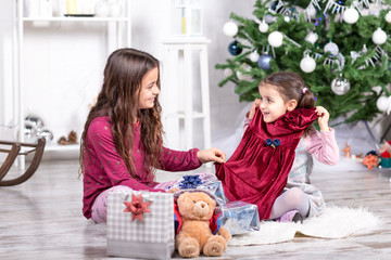 Bambine sorridenti che aprono i regali di Natale
