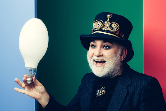 smiling man holds light bulb - Powered by Adobe