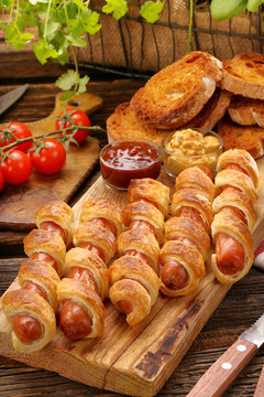 Rolled hot dog sausages baked in puff pastry and salad