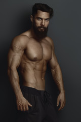 bearded bodybuilder against the dark wall