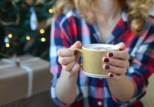 Lady's hands holding cup with cappuccino
