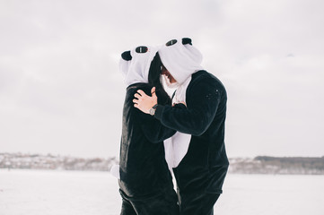 winter love story, a beautiful young couple in suits pandas