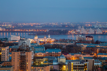 Fototapeta premium Evening cityscape from rooftop. Houses, trade centers, bridges, churches 