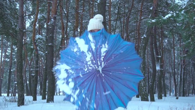 girl open an umbrella in snow forest