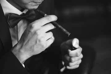 the groom in a suit smoking cigar