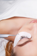 Obraz na płótnie Canvas Eyelash Extension Procedure. Woman Eye with Long Eyelashes. Lashes, close up, selected focus.
