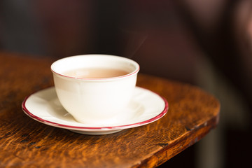 A cup of hot tea on a brown table © misign