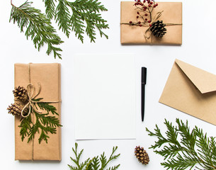 Gift boxes in eco paper and a letter on white background. Christmas or other holiday concept, top...