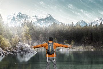 Wanderer steht an einem Bergsee