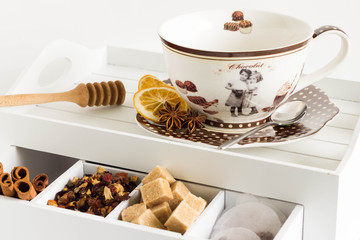 Teacup and utensils on white drawer.