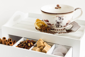 Teacup and ingredients on white drawer.