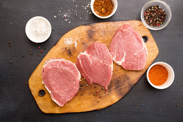 Cooking dinner. Overhead pieces raw pork steaks and condiment