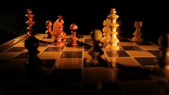 Static shot of a person playing chess isolated on black.Dramatic Lighting