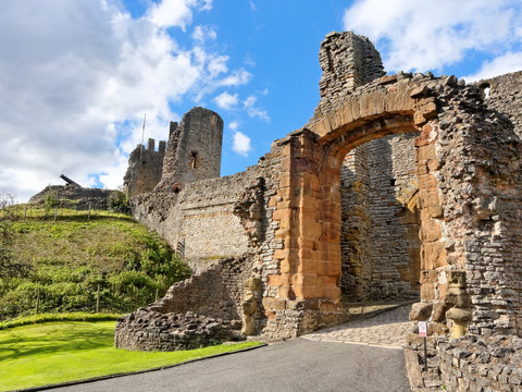 The main entrance gate to the Dudley Castle ruins. The tower and cannon against a blue sky.
