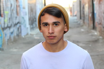Close up portrait of a young man with beanie and piercing or nose ring 