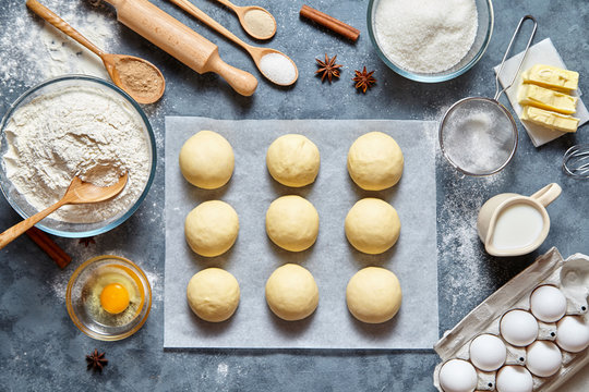 Buns dough traditional homemade preparing recipe, ingridients food flat lay on kitchen table background. Working with butter, milk, yeast, flour, eggs, sugar pastry or bakery cooking.