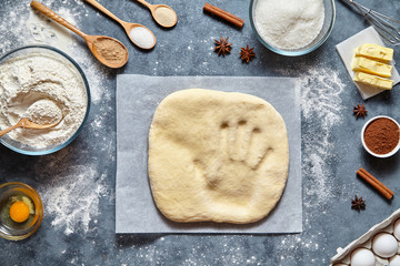 Dough bread, pizza or pie recipe homemade preparation. Handprint on dough. Food ingridients flat lay on kitchen table. Working with pastry or bakery cooking. Top view