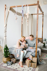 Fototapeta na wymiar Happy young parents with baby boy in christmas decorated room