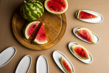 Slices of watermelon. Children's hands cooking fruit salad. Top view