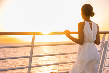 Cruise ship vacation woman enjoying sunset on travel at sea. Elegant happy woman in white dress...