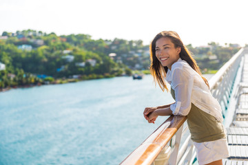 Fototapeta premium Cruise ship vacation Asian woman relaxing on deck enjoying view from boat of port of call city on St. Lucia island in the Caribbean. Happy casual tourist girl outside on tropical holiday destination.