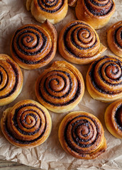 Cinnamon roll bread, buns, rolls on parchment paper. Homemade bakery. Top view. Sweet Homemade...