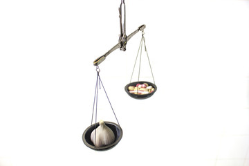 balance scale with pills and garlic