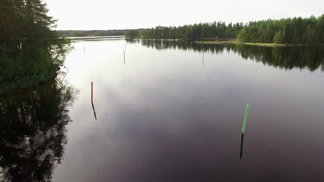 Backlight aerial shot of moving between red and green lateral buoys on a waterway