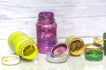 Multicolored plastic cans with paints. Artist workplace background. Old dirty Paints background. Colorful artist palette. Creativity, visual art concept. Art and craft.