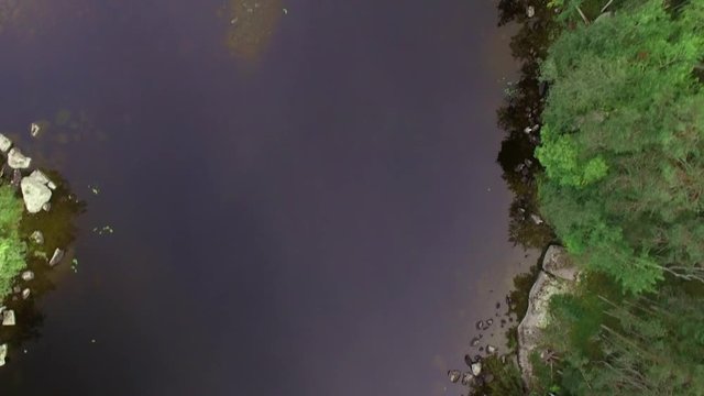 Aerial vertical shot, navigating above a strait sea lane between shoals at a Finnish lake