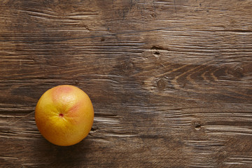 single organic grapefruit on wood table
