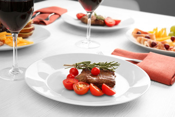 Steak and appetizers with wine on table