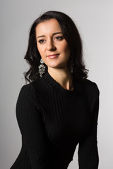 Obraz premium Lovely girl with black hair on a gray background