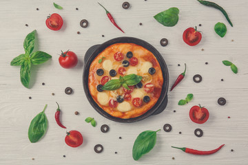 Delicious pizza with ingredients and spices on table