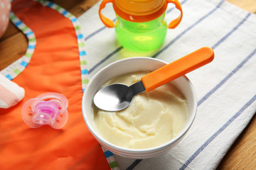 Bowl with healthy baby food on table. Child feeding concept