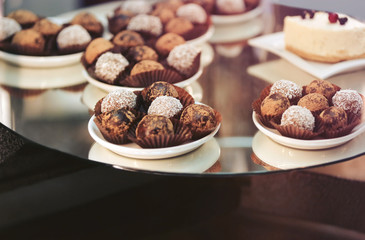 Glass stand with tasty sweets in cafe, close up view