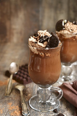 Two portions of hot chocolate with wipped cream and cookies.