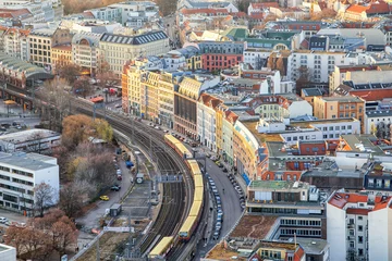 Schilderijen op glas Beautiful panoramic aerial view over Berlin down onto S-Bahn tracks (rapid train) and colorful buildings at sunset. © indigo641