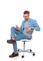 Young man sitting on chair and using mobile phone
