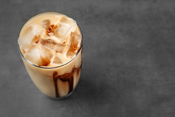 Iced coffee with milk on grey background