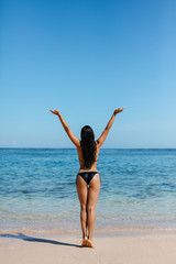 Fototapeta na wymiar Young woman in bikini on the beach