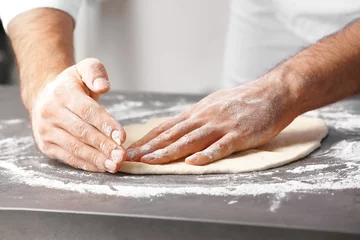 Photo sur Plexiglas Pizzeria Male hands preparing dough for pizza on table closeup