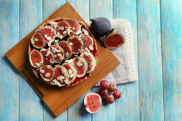Delicious fig cake with almond flakes on wooden cutting board