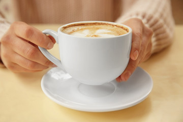 Woman holding cup of coffee, closeup