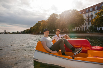 Teenage boys boating on the lake in city