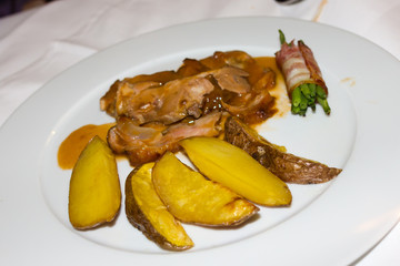 Roast veal with potatoes and asparagus and bacon